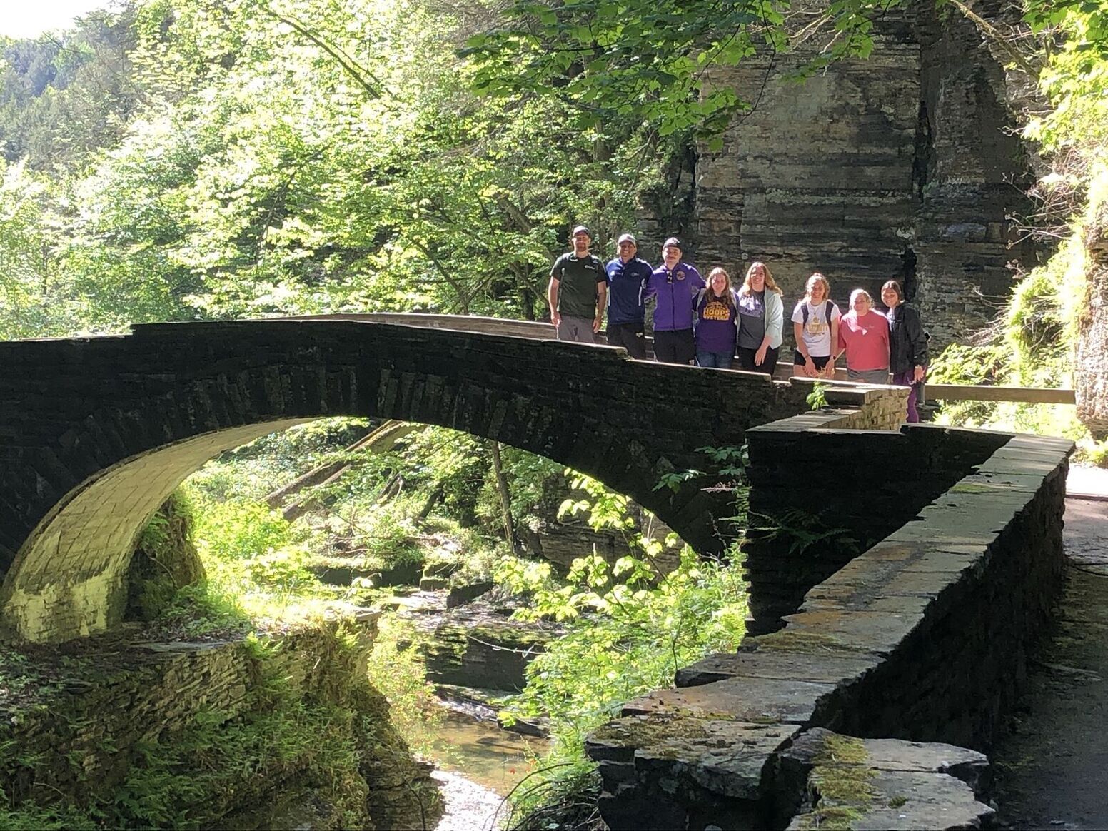 Students standing on stone bridge at a local park
